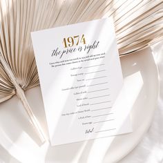 a white plate topped with a menu next to an open book and palm fronds