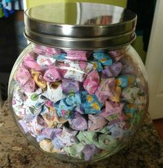 a glass jar filled with candy sitting on top of a counter