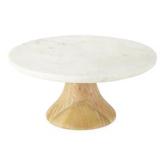 a white marble topped table with wooden base on an isolated white background for use as a cake stand