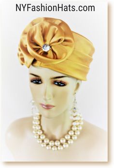 Women's Antique Gold Satin Couture Formal Pillbox Cocktail Wedding Church Hat. This Classic Styled Dressy Pillbox Holiday Hat Is Embellished With A Satin Bow Enhanced With A Rhinestone. This Bridal Mother Of The Bride Headpiece Can Be Worn With Embellishments Toward The Face Or To The Back Of The Head. This Elegant Satin Pillbox Hat Is Custom Made And Designed By NY Fashion Hats Couture Millinery. https://www.nyfashionhats.com. This New Collection Headpiece Is Part Of The Anastasia Konstandina Couture Headdress Line. This ladies bespoke pillbox hat is appropriate to wear for horse races, The Kentucky Derby, The Dubai World Cup, The Royal Ascot, The Melbourne Cup, Belmont Stakes, The Preakness Stakes horse racing, Church, weddings, and special occasion. This hat is also suited for mother of Mother Of The Bride Hats, Preakness Stakes, Brides Dress, Bridal Fascinator, Couture Hats, Women Church, Church Hat, Bridal Hat, Wedding Church