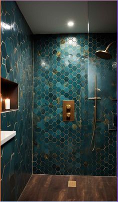 a bathroom with green tile and gold fixtures on the shower wall, along with wooden flooring