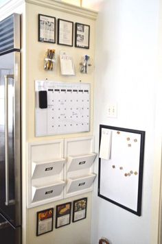 a kitchen with a refrigerator and calendars on the wall next to other magnets