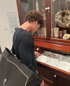 a woman looking at artifacts in a glass case