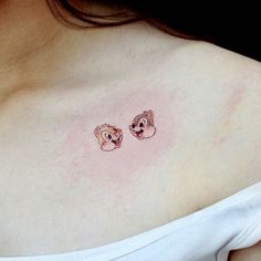 a woman's chest with two small cartoon animals on the left side of her breast