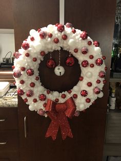 a christmas wreath with red and white ornaments