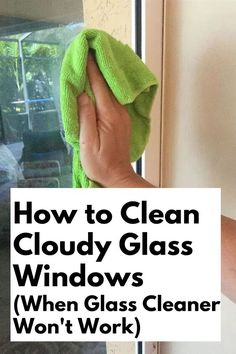 a person wiping windows with a green cloth