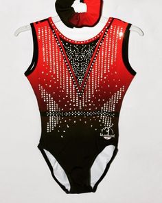 a red and black leotard with silver sequins on the back, attached to a white wall