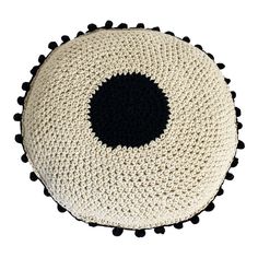 a black and white pom - pom pillow on a white surface with a black circle in the middle