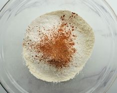 a glass bowl filled with dry ingredients on top of a table