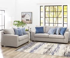 a living room with two couches and a rug in front of the window,