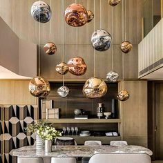 an elegant dining room with marble tables and chairs, hanging balls from the ceiling above