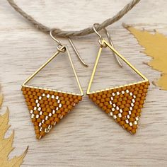 "Leo: July 23 to August 22.  Power color: Orange and/or Gold 0.875\" wide and 1.875 long.  Built on a stainless steel triangle for a geometric (tarnish free) airy and dainty flair. Heavy gauge gold filled ear wires are sturdy and hypoallergenic. A perfect accessory for the generous and brave fire sign!" Geometric Beaded Gold Earrings, Gold Beaded Geometric Earrings, Geometric Gold Beaded Earrings, Gold Geometric Beaded Earrings, Geometric Beaded Gold Jewelry, Gold Beaded Geometric Jewelry, Geometric Gold Beaded Jewelry, Gold Triangle Beaded Bohemian Earrings, Gold Geometric Beaded Jewelry