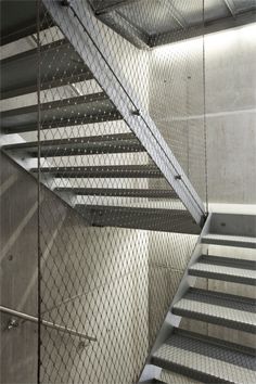 a metal stair case next to a set of stairs