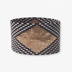 a black and tan woven bracelet on a white background