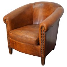 a brown leather chair with nailing on the armrests and back rests against a white background