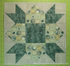 a green and white patchwork quilt on a cutting board