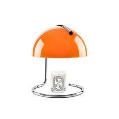 an orange table lamp with a white cup underneath it