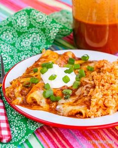 a plate of mexican food with rice, beans and sour cream on it next to a jar of syrup