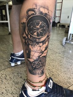 a man's leg with a compass tattoo on it