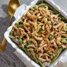 a white dish filled with green beans and mushrooms