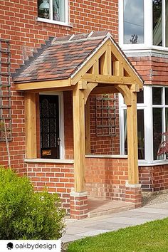 a wooden gazebo in front of a brick house