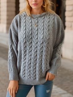 a woman wearing a gray cable knit sweater