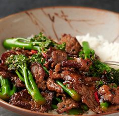 a bowl filled with meat and broccoli on top of rice