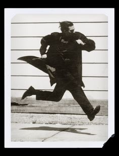 a black and white photo of a man jumping in the air