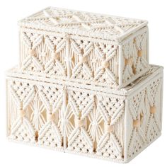 two white crocheted boxes sitting on top of each other