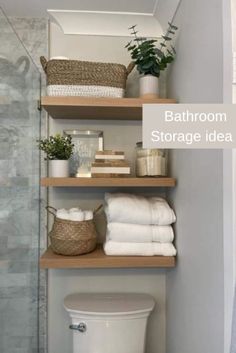 bathroom storage idea with shelves above the toilet and towels in baskets on top of them