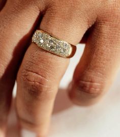 a close up of a person's hand with a wedding ring on their finger