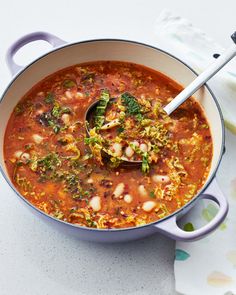 a bowl of vegetable soup with a ladle full of the soup is ready to be eaten