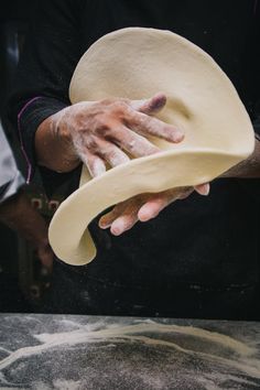 a person with their hands on top of a hat