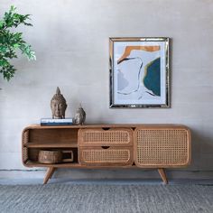 a wooden sideboard sitting next to a potted plant