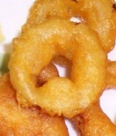 three fried onion rings sitting on top of a white plate