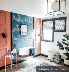 a bathroom with blue and orange wallpaper, white bathtub and rug on the floor