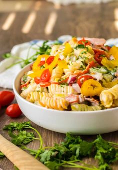 a bowl filled with pasta salad on top of a wooden table