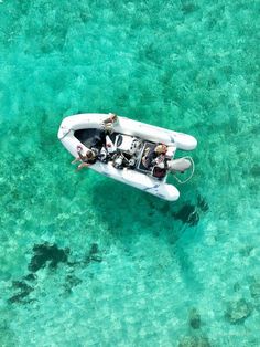 two people in a small boat on clear blue water