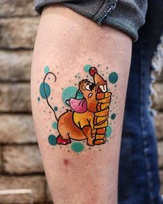 a person with a tattoo on their leg that has a dog holding a balloon in it