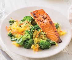 a white plate topped with broccoli and salmon