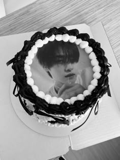 a black and white photo of a person on a cake with icing around it