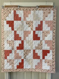 a red and white quilt hanging on the wall