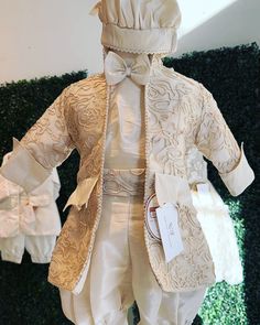 a mannequin dressed in white and gold clothing