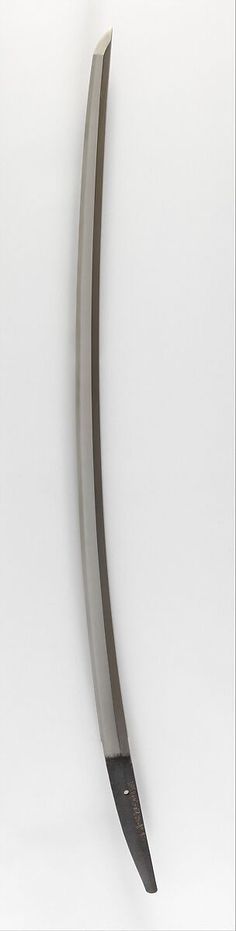 a large metal object hanging on the wall in front of a white background with a black handle