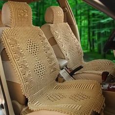 the interior of a car with two seats covered in crochet