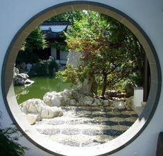 a circular window view of a garden with rocks and trees