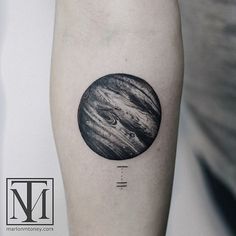 a black and white photo of the planets tattoo on the right arm, with space in the background