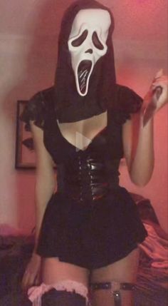 a woman wearing a mask and skirt with her mouth open in front of the camera