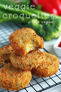 some fried food on a cooling rack with broccoli and tomatoes in the background