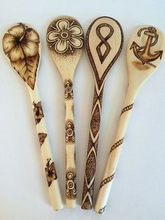 four wooden spoons with designs on them